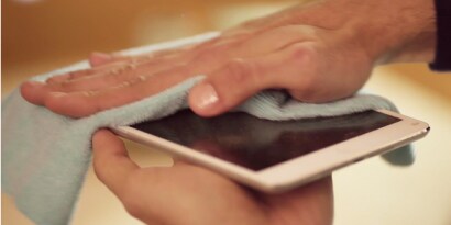 Manos limpiando un celular con el Paño de Microfibra  Scotch-Brite.
