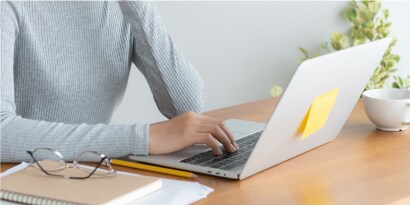Persona trabajando en una laptop en un entorno limpio y ordenado.
