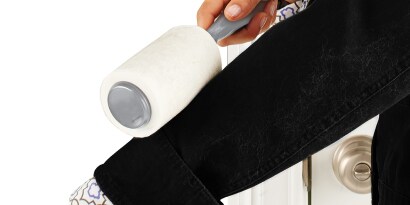 Mano quitando la pelusa de un saco con Rodillo Quita Pelusa Scotch-Brite.
