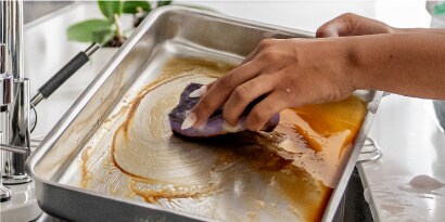 Limpiando restos de comida en trastes con Esponja Extrema Scoth-Brite.
