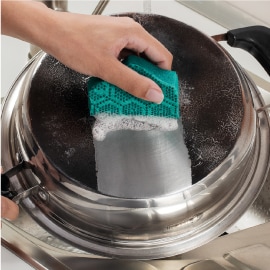 Limpieza de olla de aluminio con la fibra Esferas de Limpieza Scotch-Brite.