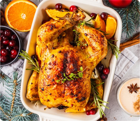 Pavo en recipiente en medio de la mesa de Navidad.

